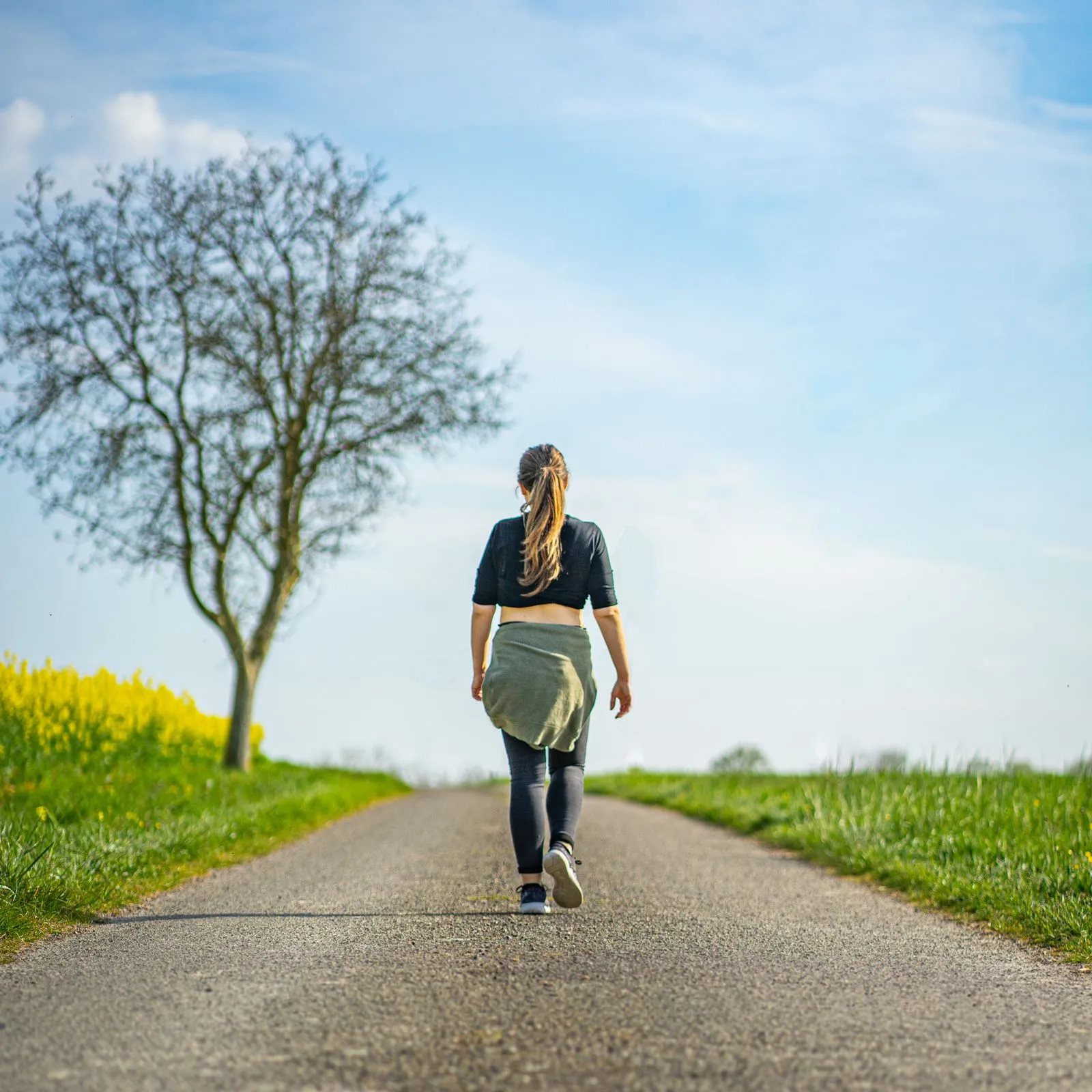 A person walking outdoors at the start of a new exercise habit